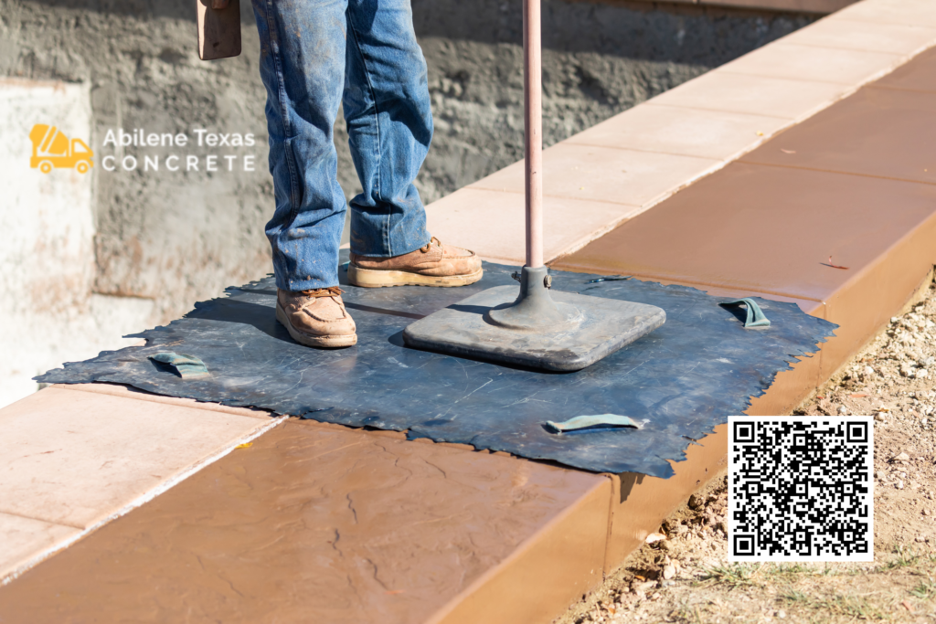 A worker forming stamped concrete designs.